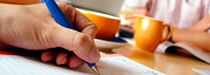 Photo of someone writing with a pen on a table